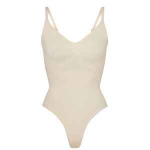 Skims Seamless sculpt thong bodysuit in sand. Snap closure.